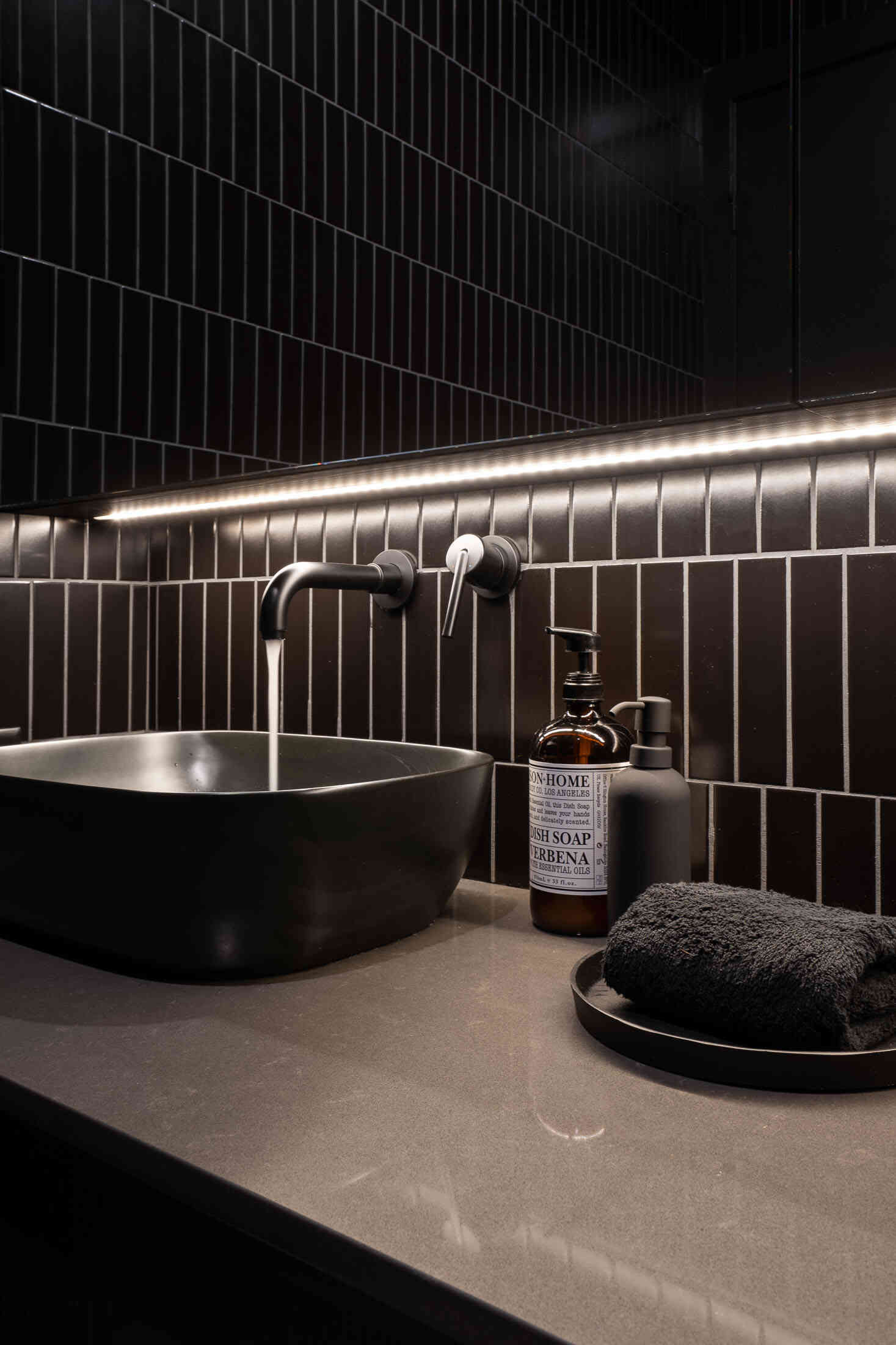 Black powder room with Caesarstone Raven countertops and vessel sink.