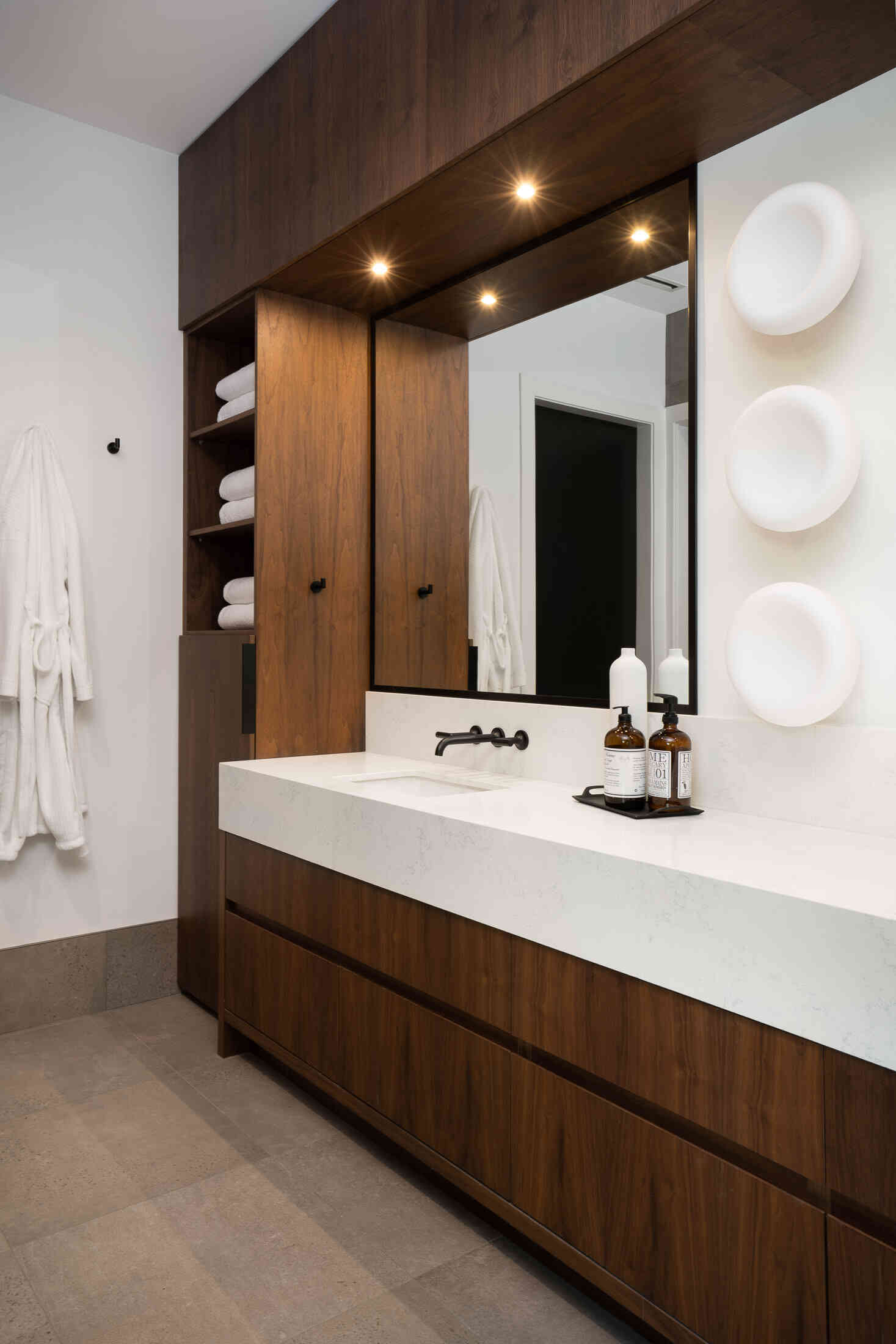 Walnut vanity with mitred-edge quartz countertops in bathroom
