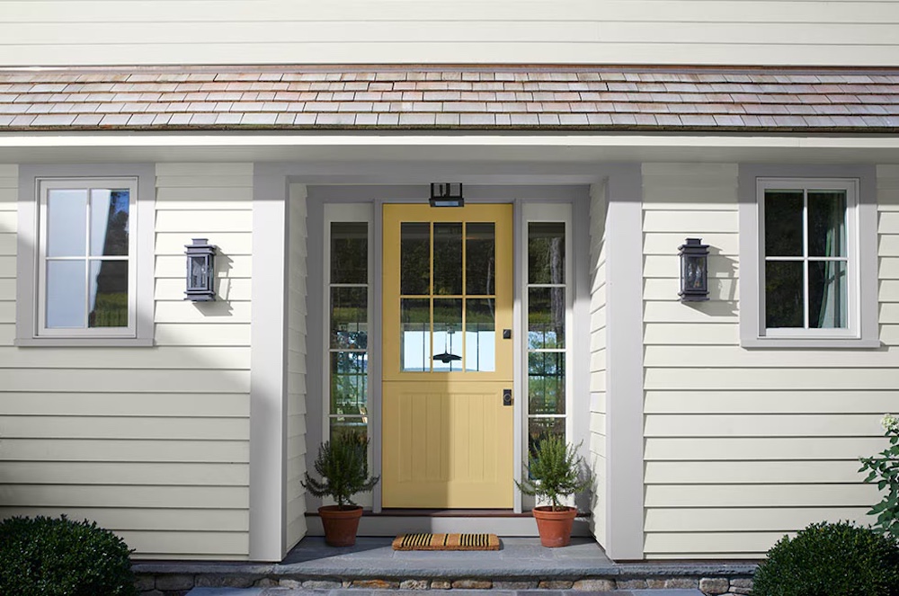 yellow painted door on white house with grey trim